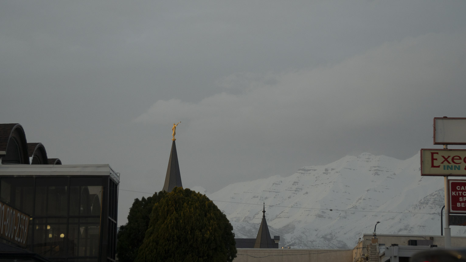 Strikingly gold angel on steeple on a cloud day